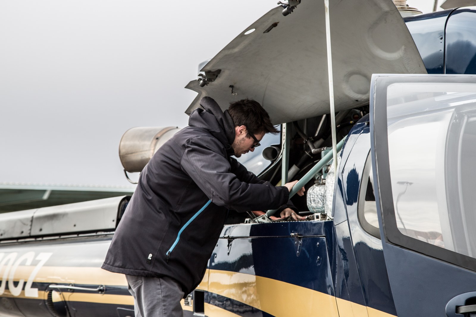 Technician working in the engine bay of a turbine helicopter